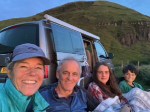Family of four including 2 teenagers sat outside the front of a Four Seasons Campers VW California Ocean