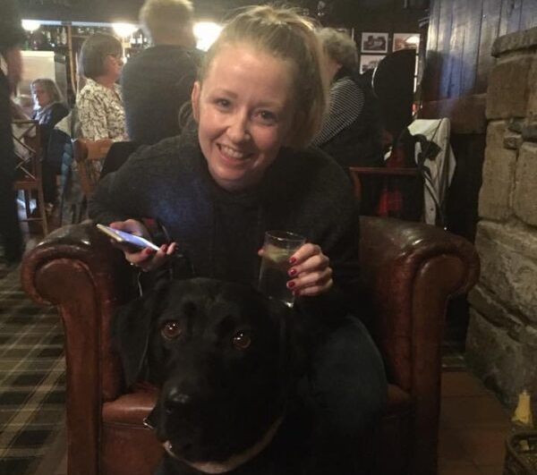 Girl with a black labrador inside the Glenelg Inn