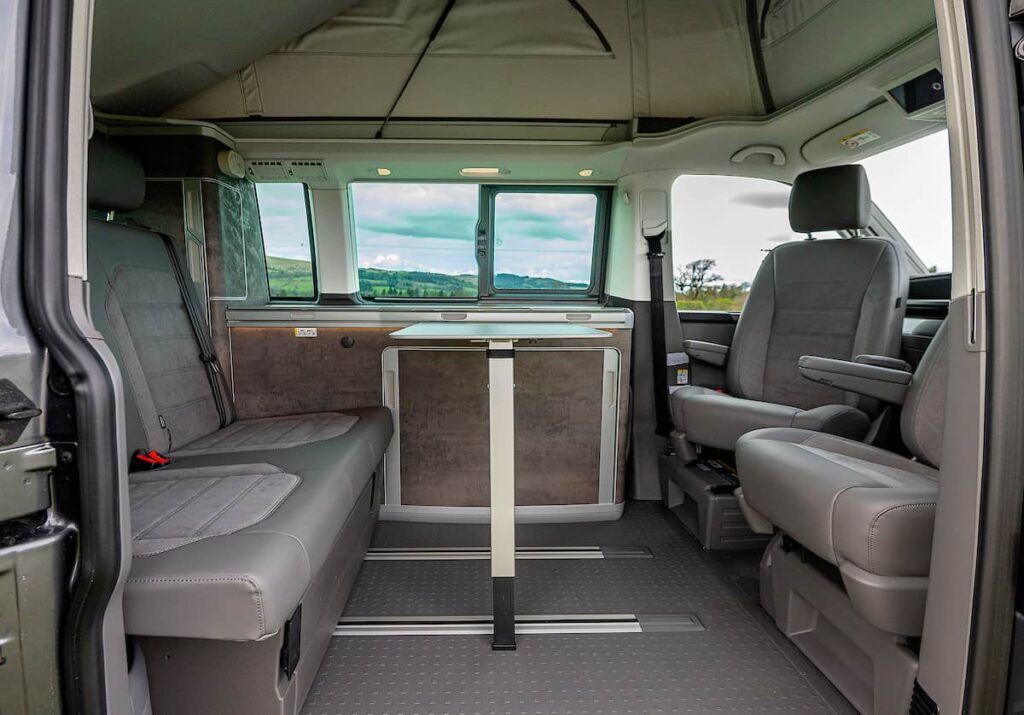 interior living area in VW California campervan with kitchen and dining table