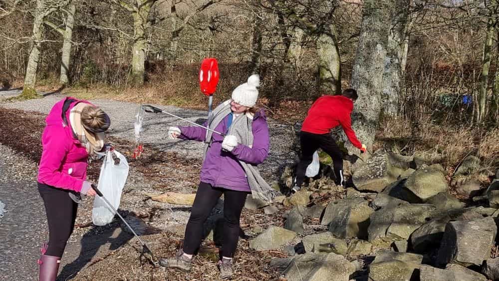 Four Seasons Campers crew taking part in two minute beach clean on the shore of Loch Lomond