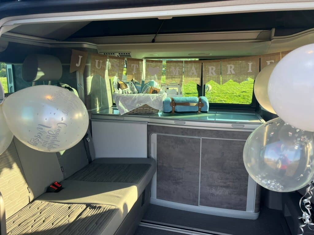 White campervan with pop up roof with table and chairs on hire near Skye with Four Seasons Campers Campervan honeymoon registry service