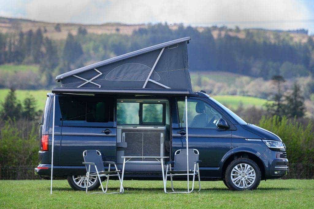 2023 4 berth VW California Ocean from Four Seasons Campers with chairs and table out side with the roof up