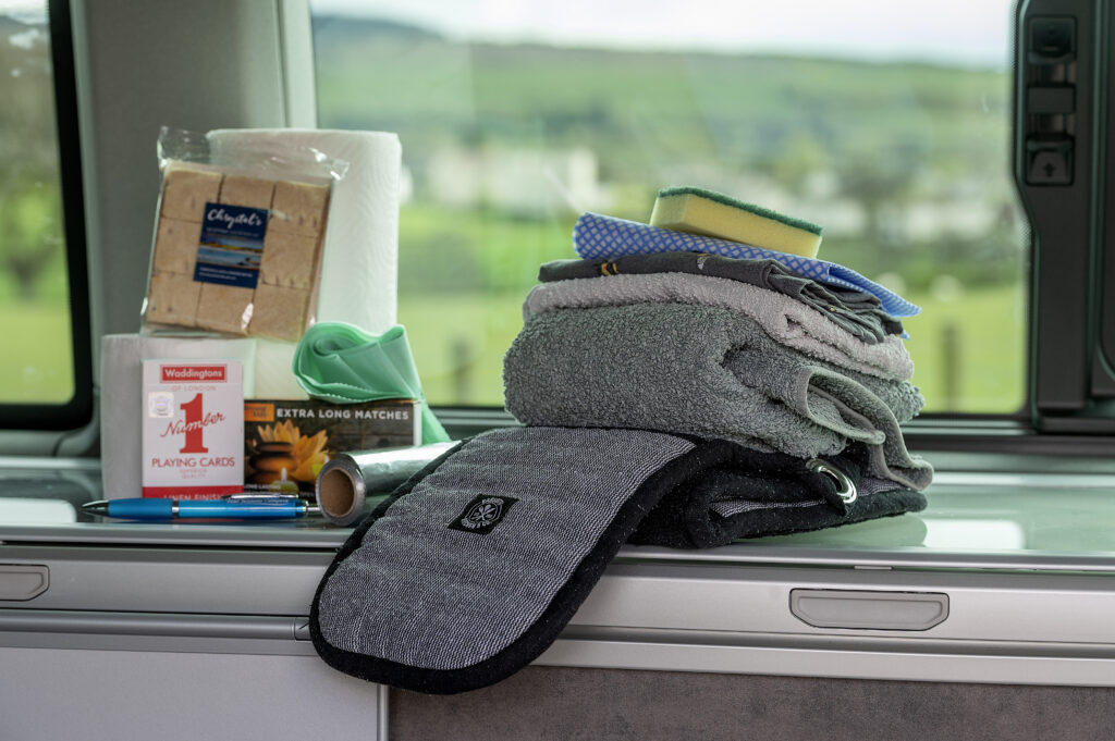 starter pack in campervan hire with oven glove, towel, cloth, cards and shortbread