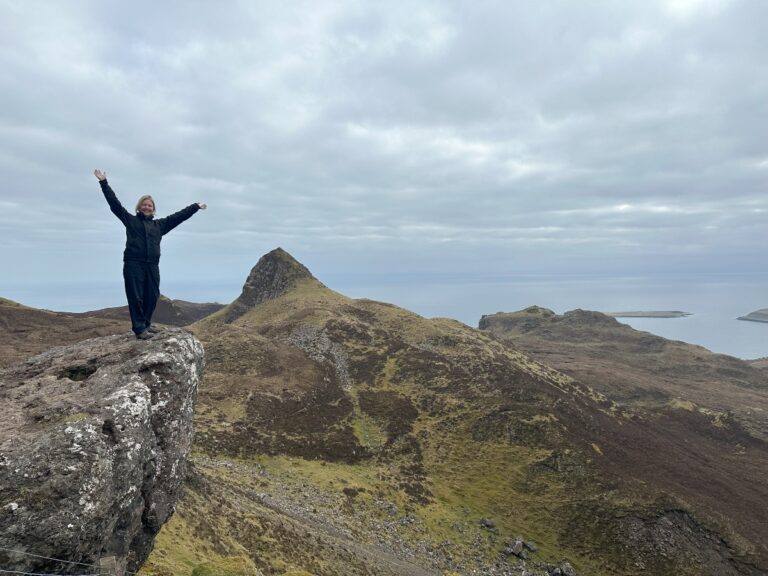 woman on top of hill in Skye at Quiraing on Four Seasons Campers road trip