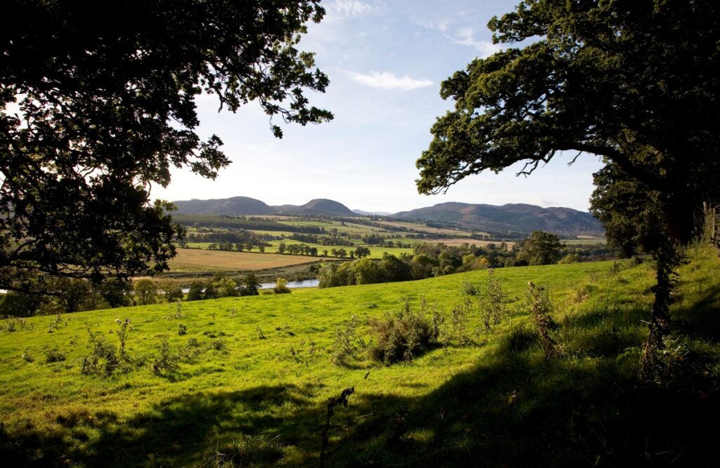 Countryside with fields and hills and trees around Beauly near Inverness in Scotland