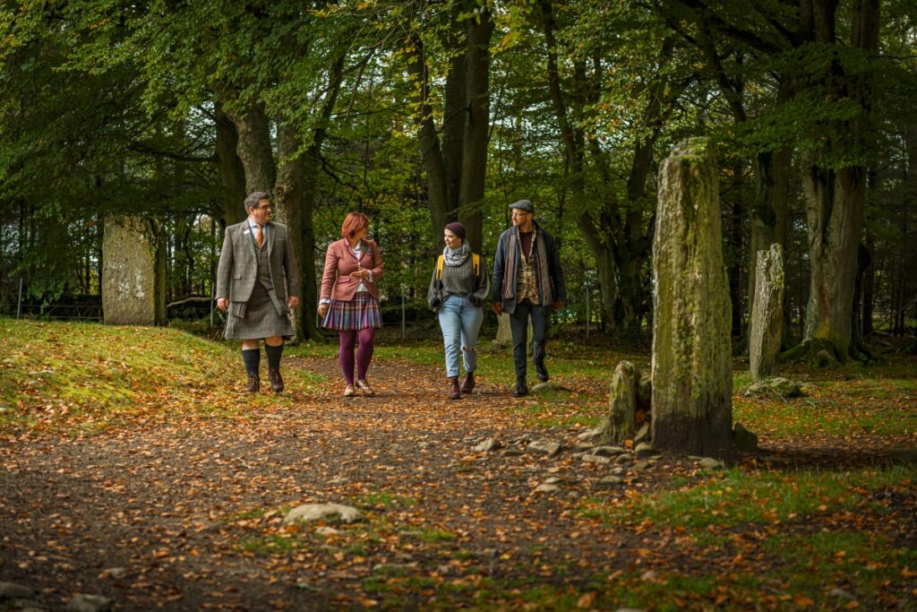 4 adults walking through stone circle Scotland