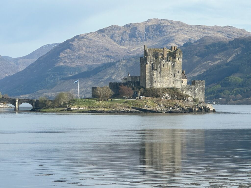 Eilean Donan Castle in Skye with Skye mountain in back ground and sea in foreground