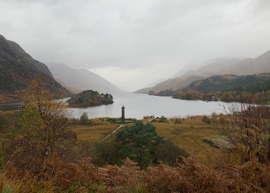 Glenfinnan monument in Scotland with loch and mountains