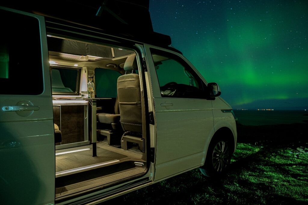 Four Seasons Campers white campervan with Northern Lights at Gairloch with green sky