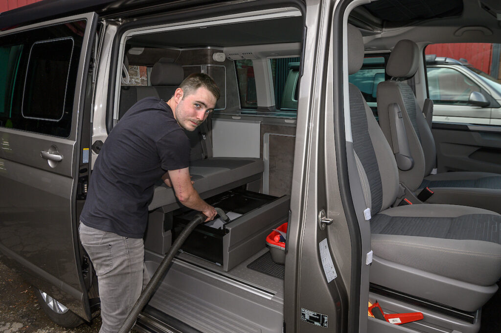 man cleaning a campervan included in hire Four Seasons Campers