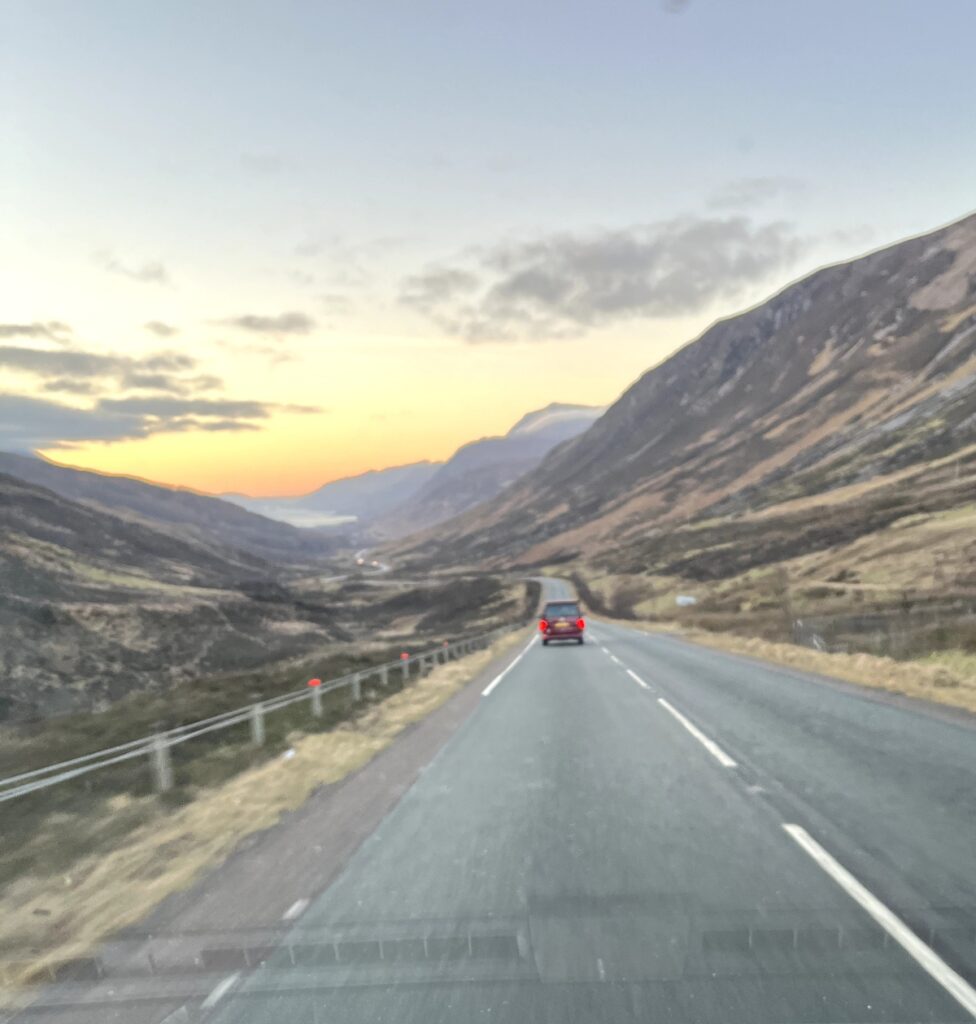 Campervan on road heading towards coast and mountains to find aurora in scotland on Four Seasons Campers road trip