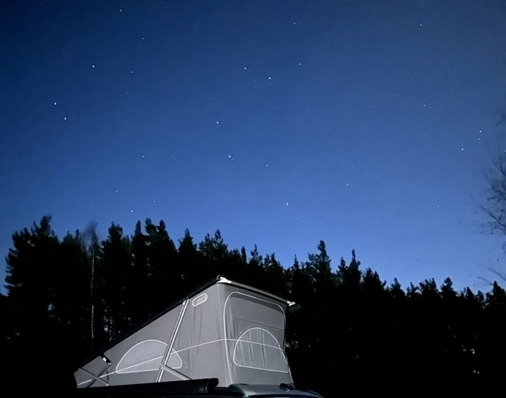 campervan pop up roof with blue sky with stars and trees on Four Seasons Campers campervan road trip