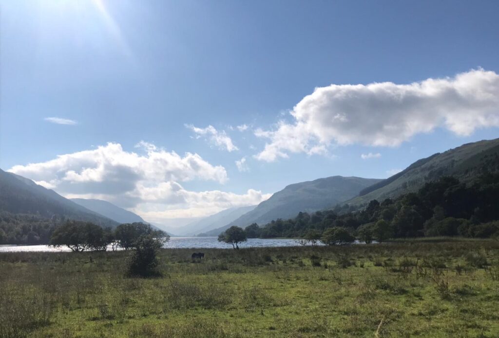 loch voil balquidder on four seasons campers campervan road trip with loch and blue sky and grass